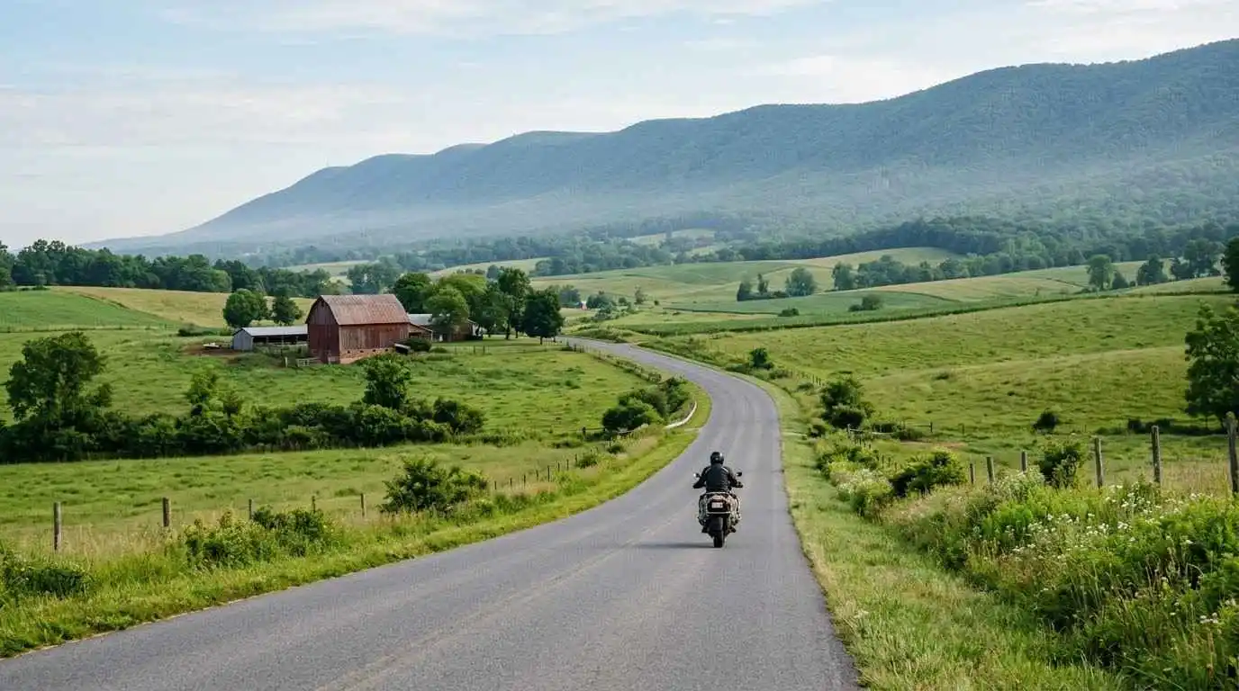 Motorcycle rider on a two-lane valley road in Page County, Virginia with Massanutten Mountain in the background.
